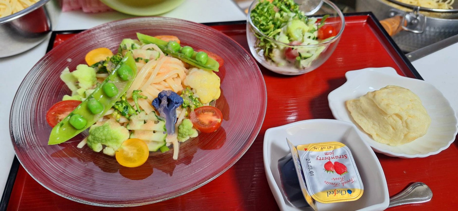 彩り野菜がのった冷製パスタに、ミニサラダと丸いスコーン、いちごジャムを添えたセット