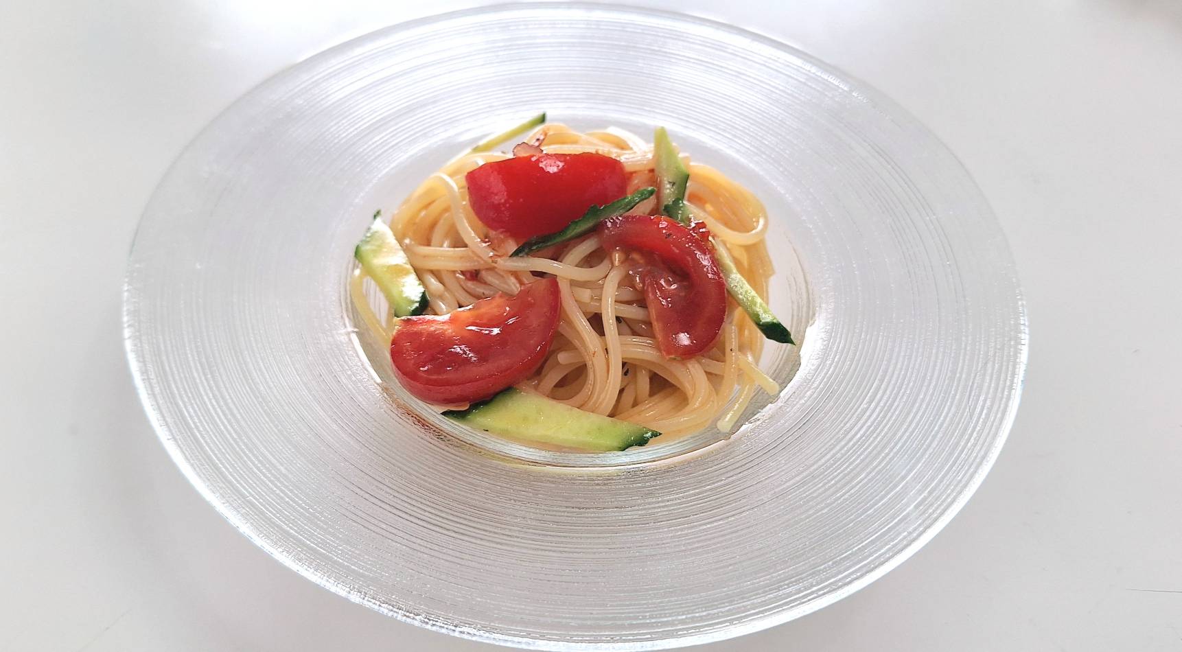 トマト味の冷製パスタをガラスのお皿に盛り付けた写真