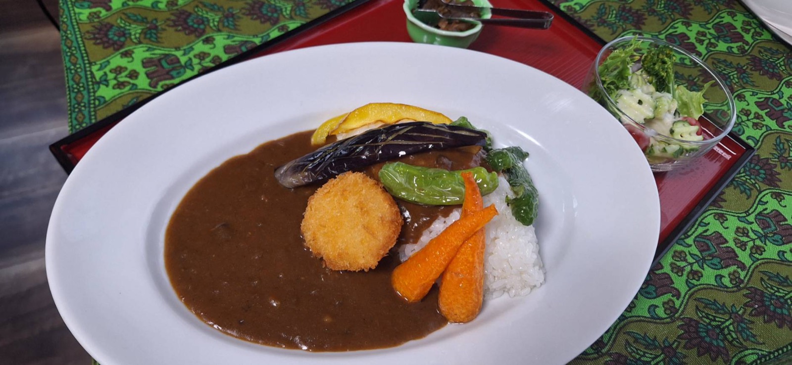 野菜たっぷりのsakuraのカレーライス、コロッケと彩り野菜をのせてミニサラダを添えたもの