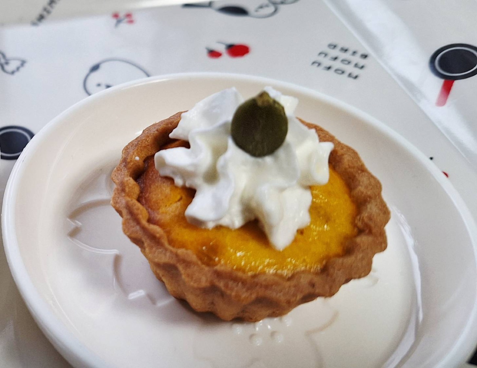 生クリームとかぼちゃの種をのせた一口サイズのカボチャケーキ