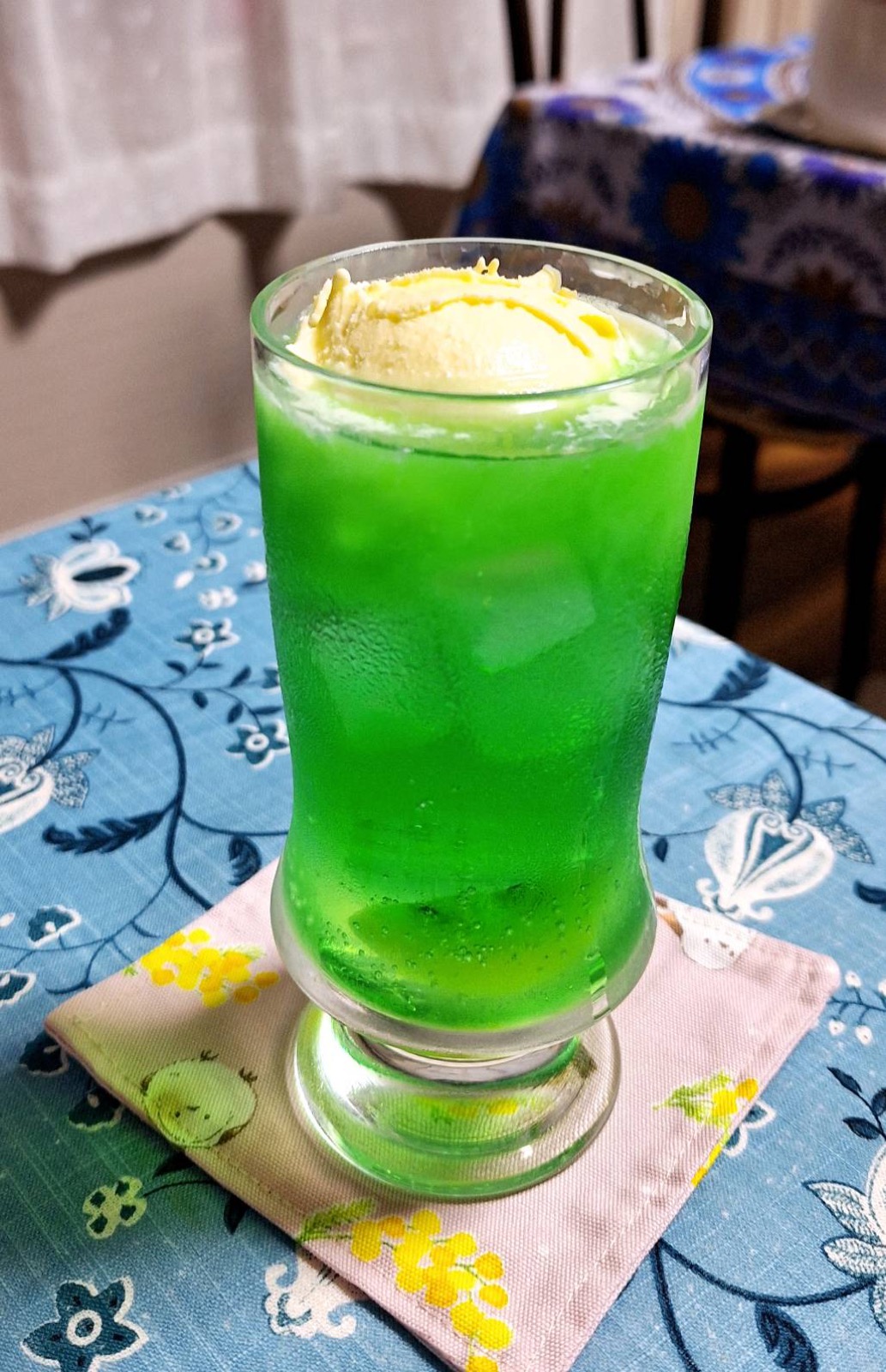 アイスをのせた鮮やかな緑色のメロンクリームソーダ