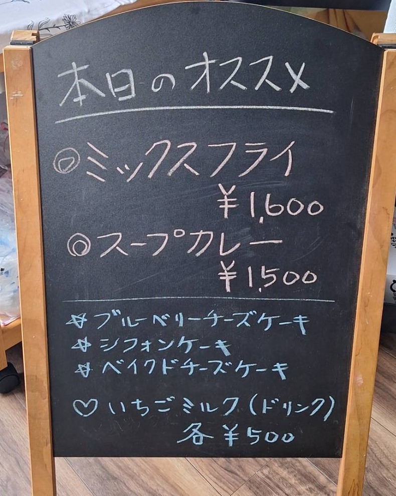 本日のオススメを知らせる黒板。ミックスフライ、スープカレー、ブルーベリーチーズケーキ・シフォンケーキ・ベイクドチーズケーキ、いちごミルク