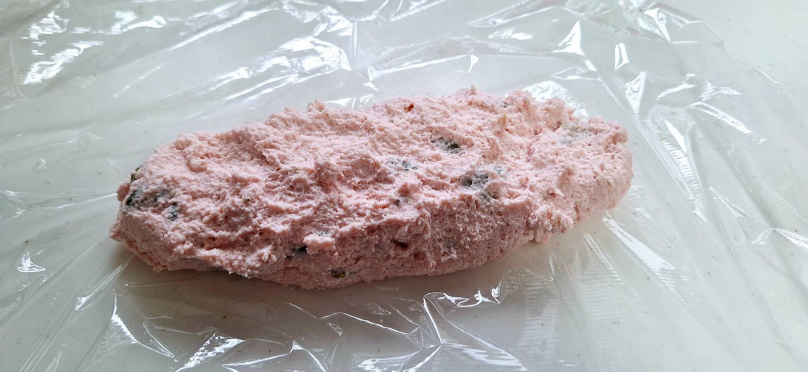 カボチャの種を混ぜ込んだ手作りチーズの生地。ピンクがかった生地に黒い種が点々と見える