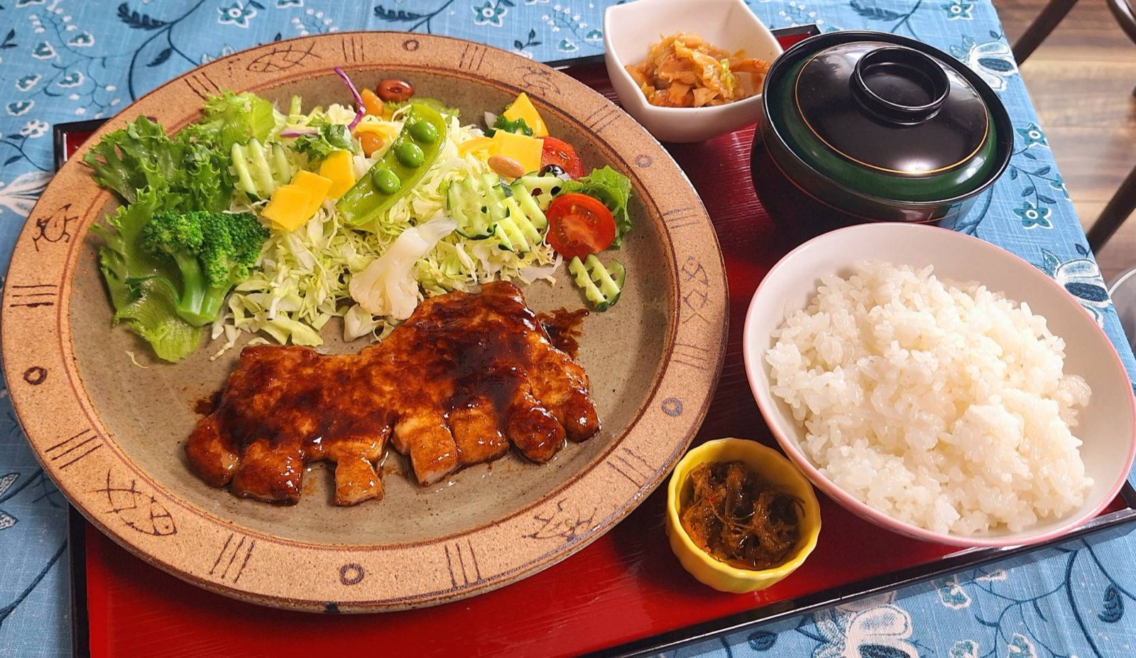 肉厚なトンテキにサラダとご飯、キムチや漬物を添えた定食