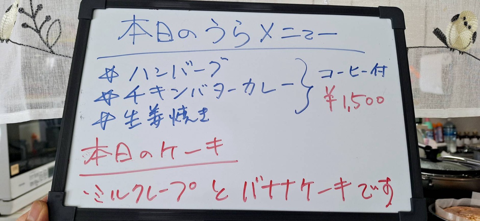 本日のうらメニューを知らせる黒板。ハンバーグ・チキンバターカレー・生姜焼き、本日のケーキはミルクレープとバナナケーキ