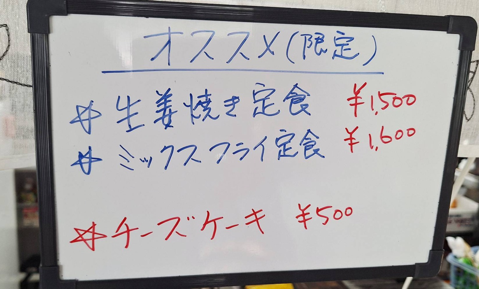 本日のオススメを知らせる黒板。生姜焼き定食、ミックスフライ定食、チーズケーキ