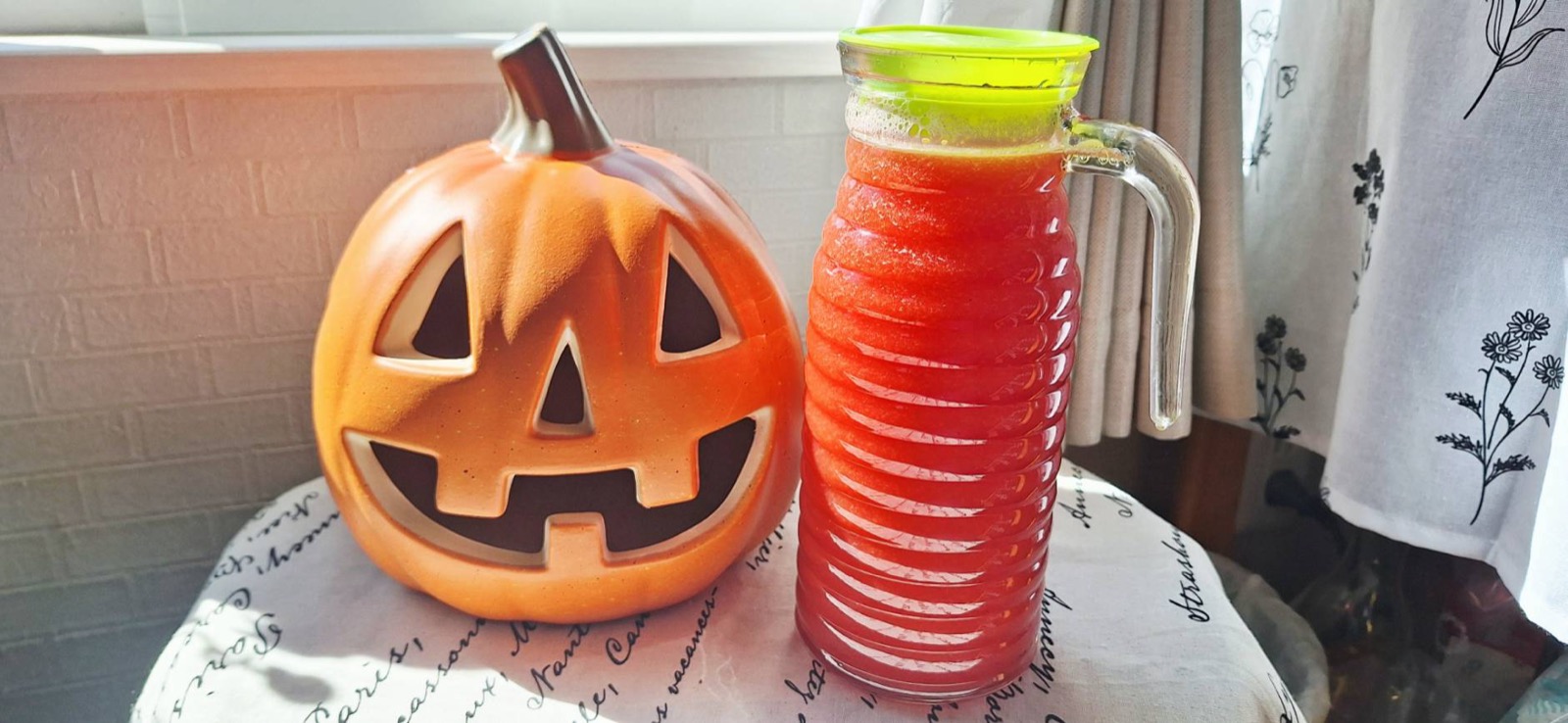 ハロウィンのかぼちゃの置物の横に並んだ瓶入りのスイカジュース